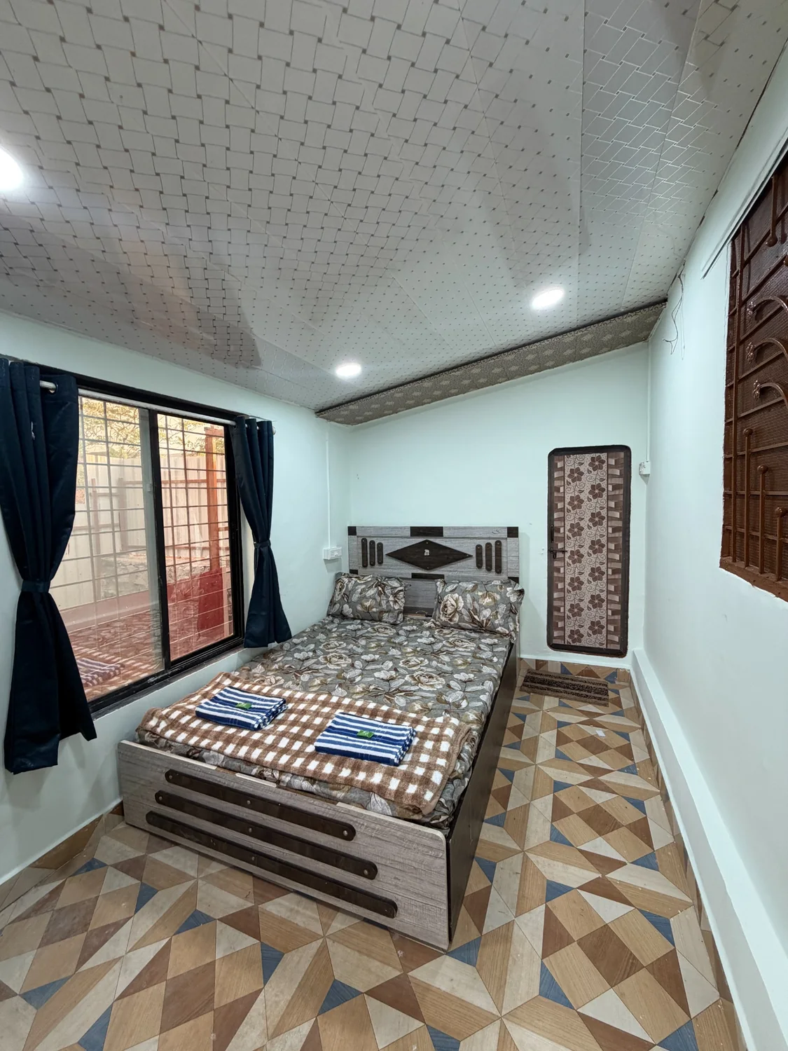 Bedroom with double bed, towels and window